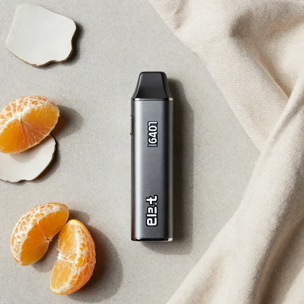 Overhead flatlay of a disposable vape with citrus segments, ceramic shard and folded cloth.